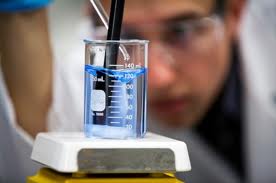 man in a lab coat testing water sample